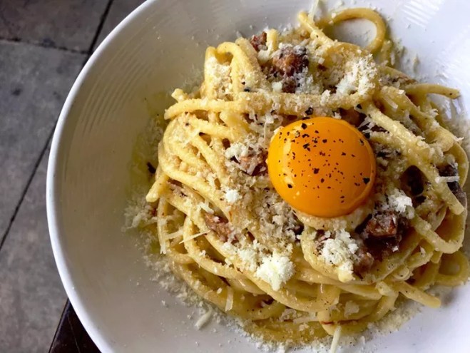 A pasta with egg yolk in a dsih