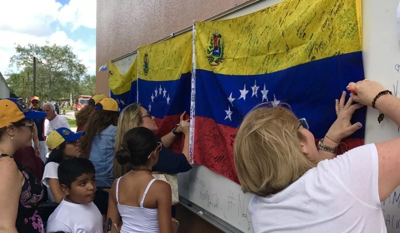 Women signing Venezuelan flags at a demonstration.