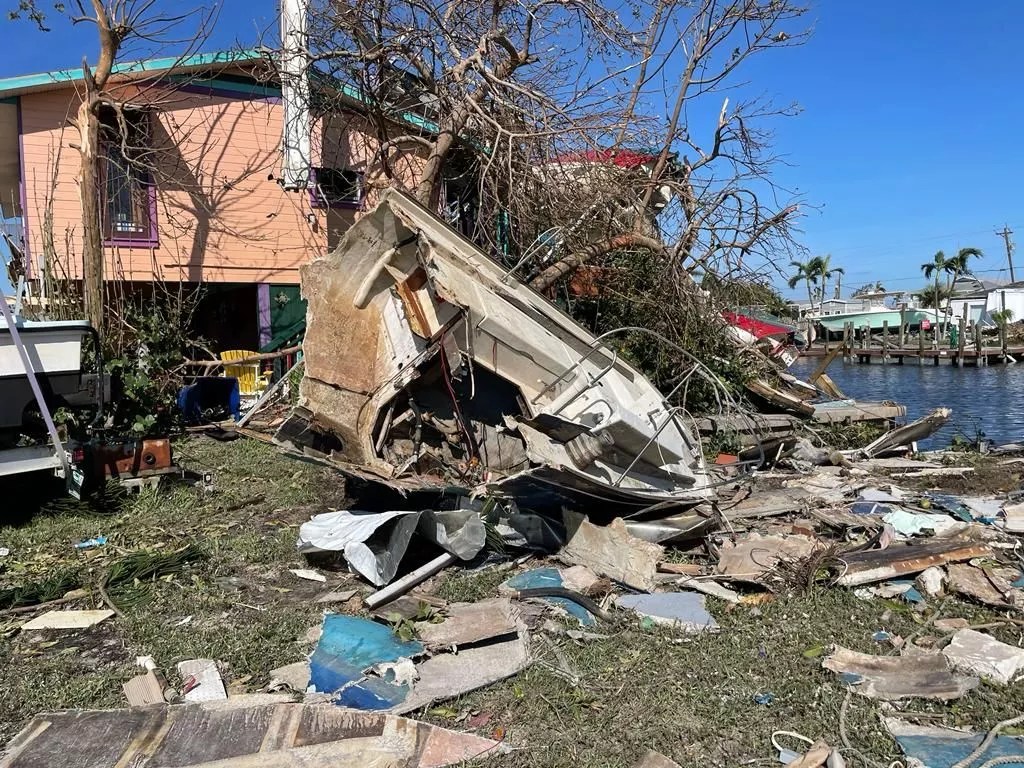 What's left a boat sits in a residential yard surrounded by debris in the aftermath of Hurricane Ian
