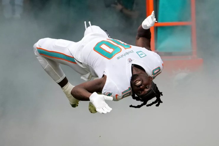 Miami Dolphins wide receiver Tyreek Hill, captured mid-backflip during the team's player introductions at Hard Rock Stadium in November 2022.