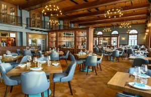 A dining room with blue seats and golden chandeliers