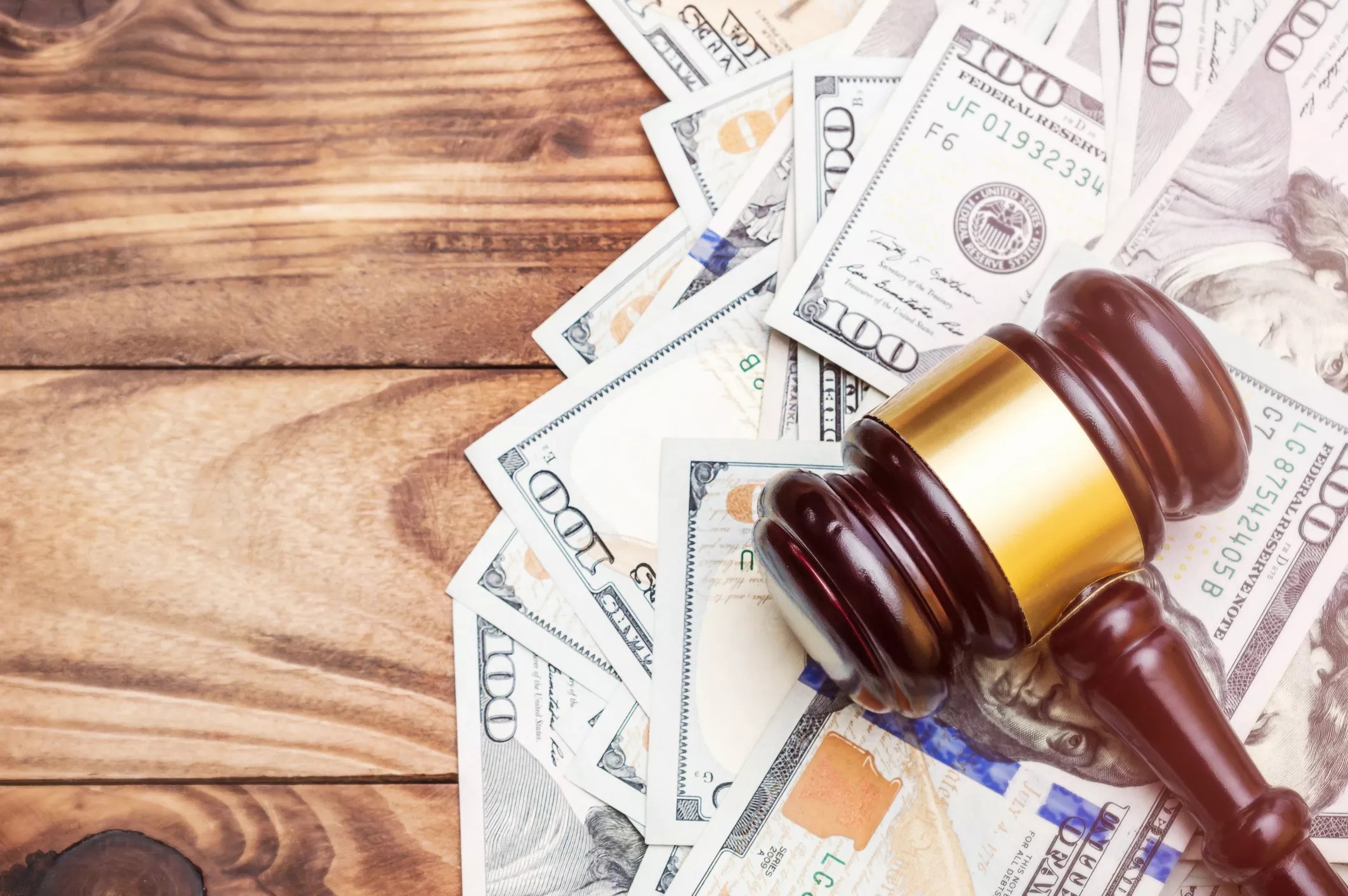 Stock photo of a judge's gavel on a pile of money