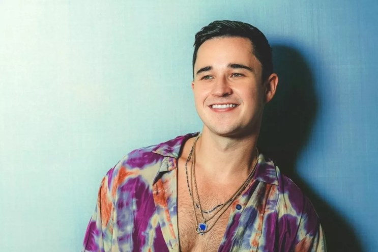 DJ and producer John Summit standing against a blue background