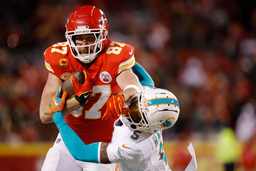 Travis Kelce darts down the field, stiff-arming a Miami Dolphins cornerback.
