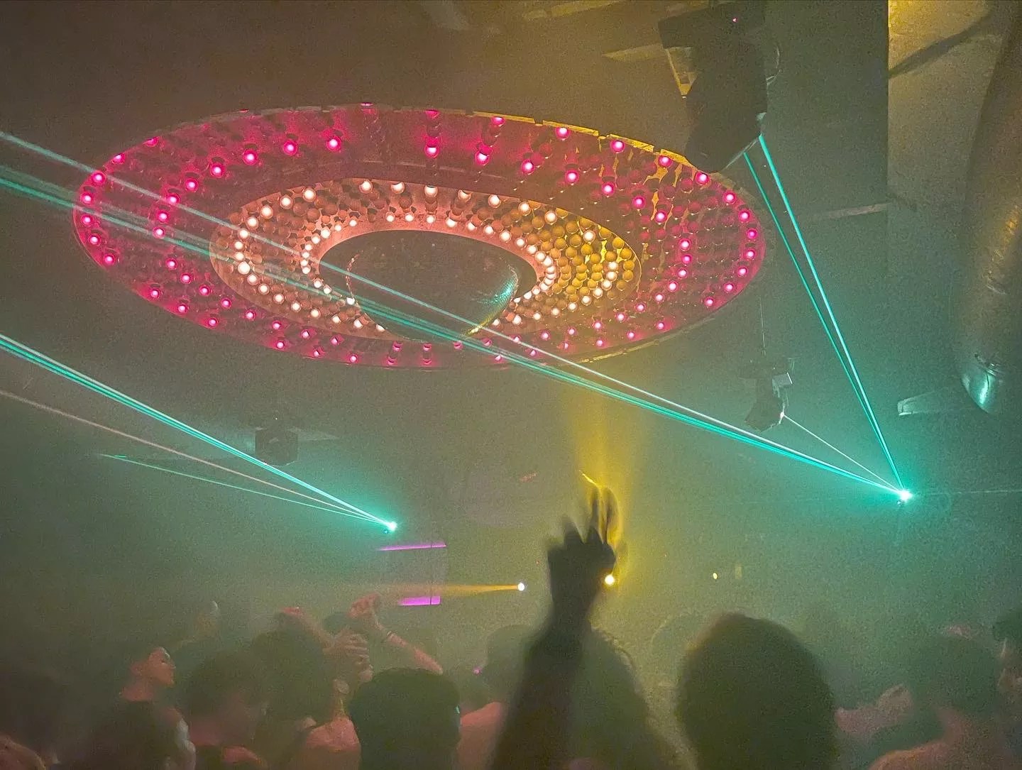 The disco ball illuminates and partygoers throw their hands in the air