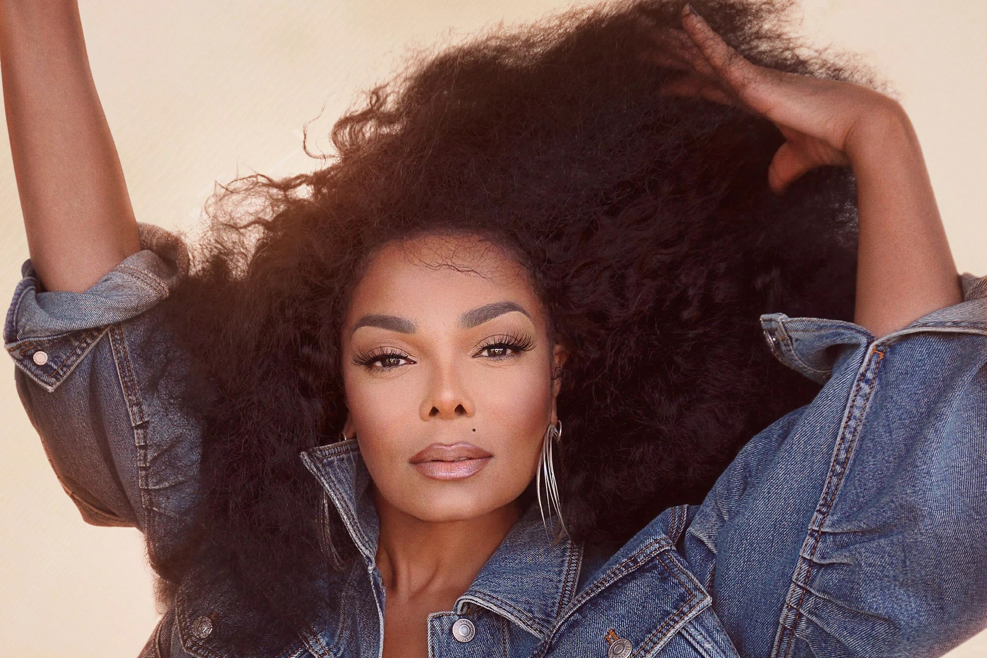 Janet Jackson starring at the camera while brushing her hair with her fingers