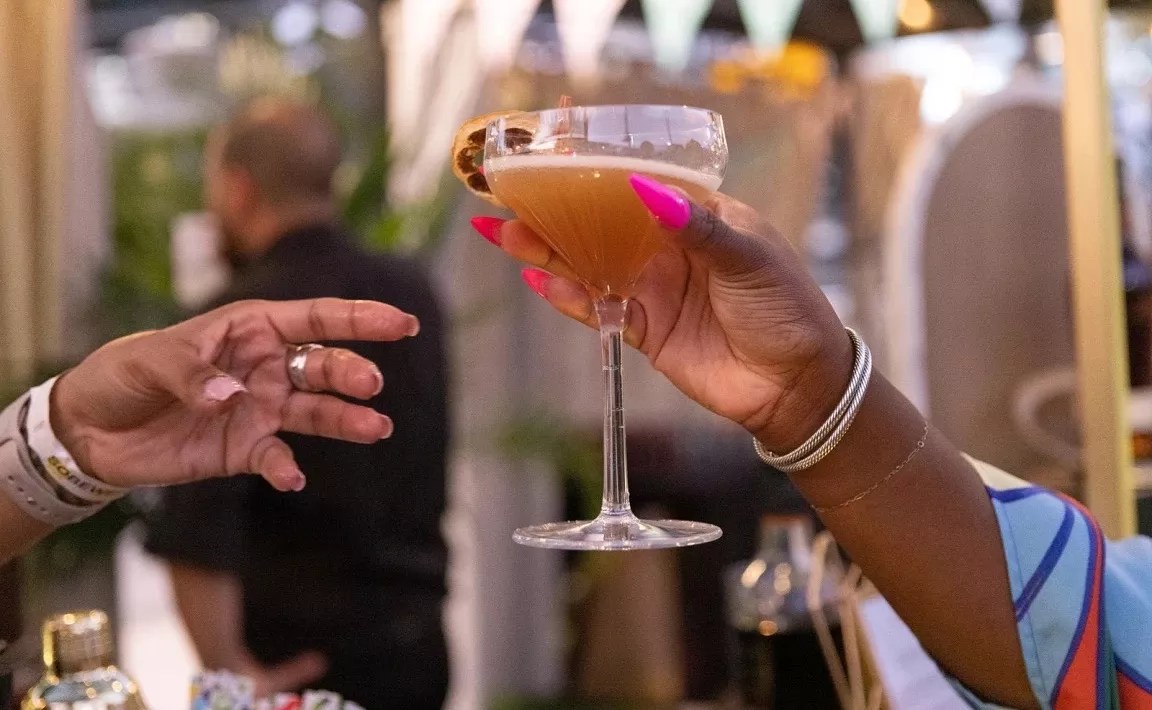 Two people holding drinks in cocktail glasses