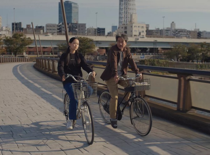 Koji Yakusho and Arisa Nakano on bikes in the film Perfect Days
