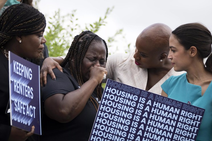A crying woman stands next to three U.S. House representatives at a Capitol Hill press conference