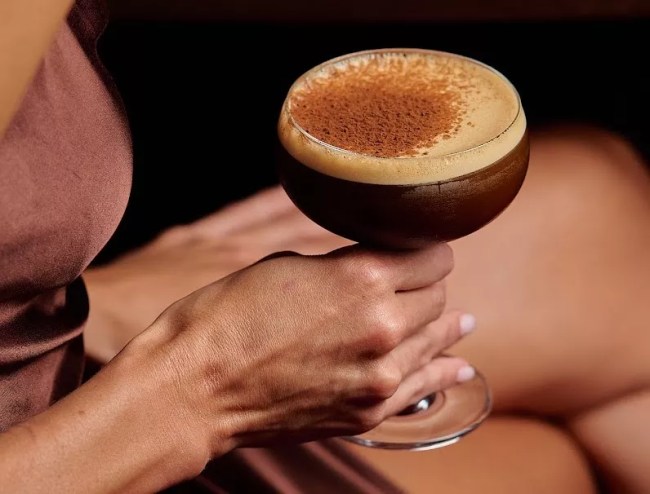 A woman holding a coffee cocktail