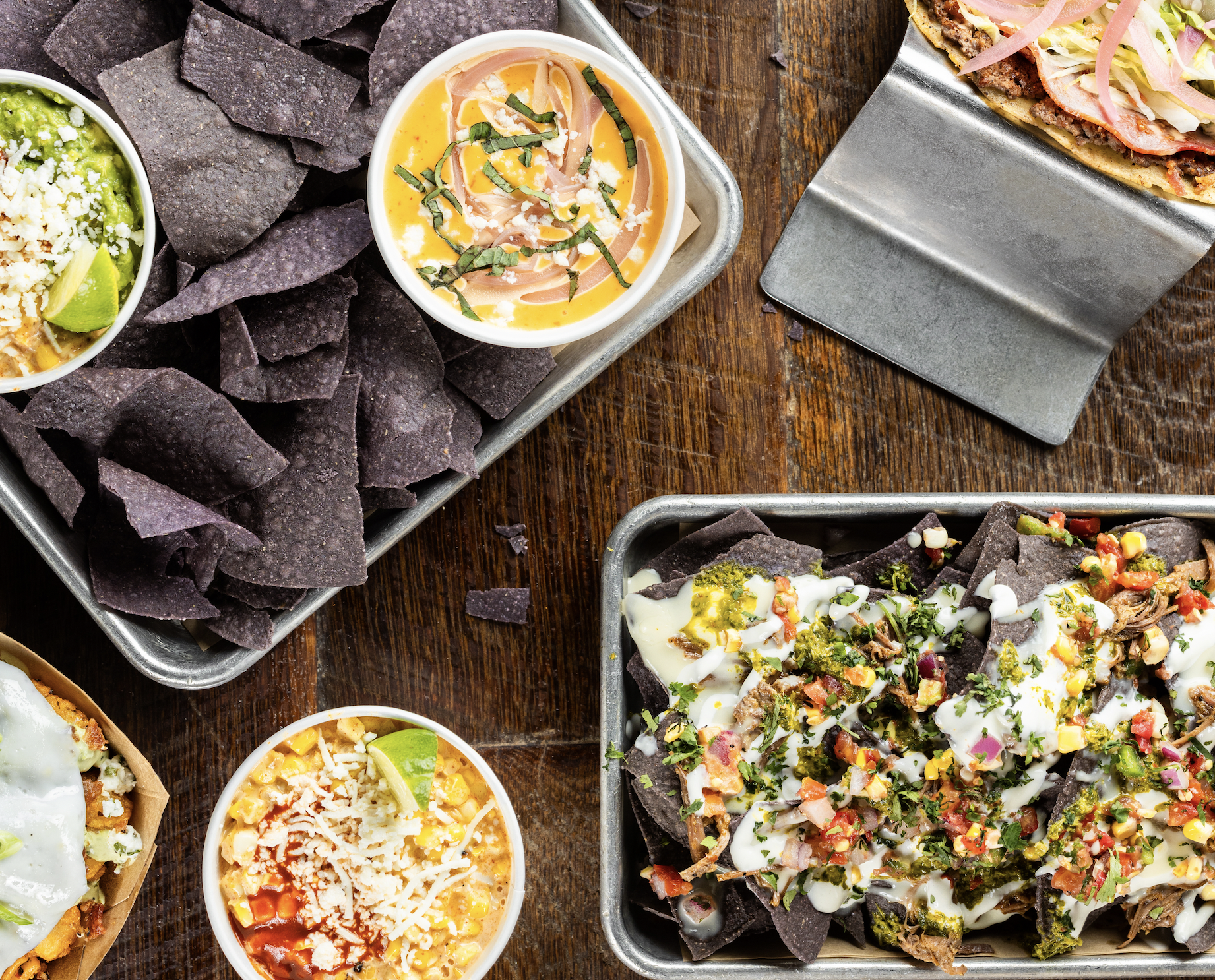 Platters of Tex-Mex dishes on a wooden table
