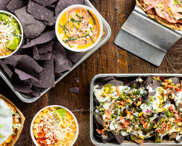 Platters of Tex-Mex dishes on a wooden table
