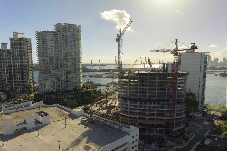 Panoramic view of a skyline with a building site and cranes in the forefront