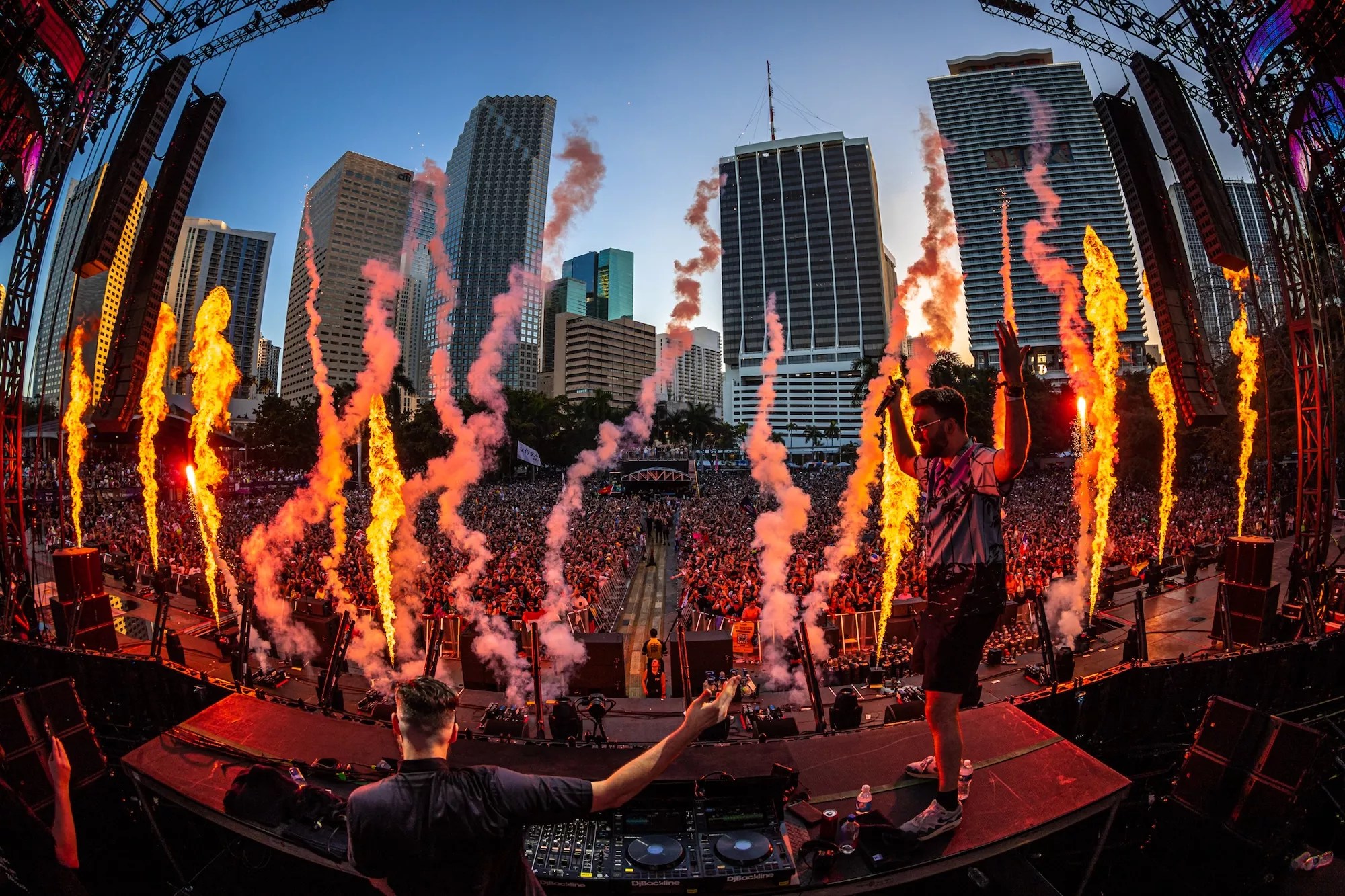 DJ performing on the main stage at Ultra in front of a huge crowd against the downtown Miami skyline