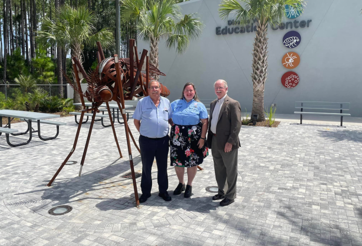 Richard Weaver from the Anastasia Mosquito Control District and two other people stand in front of the Disease Vector Education Center and Science Museum in St. Augustine.