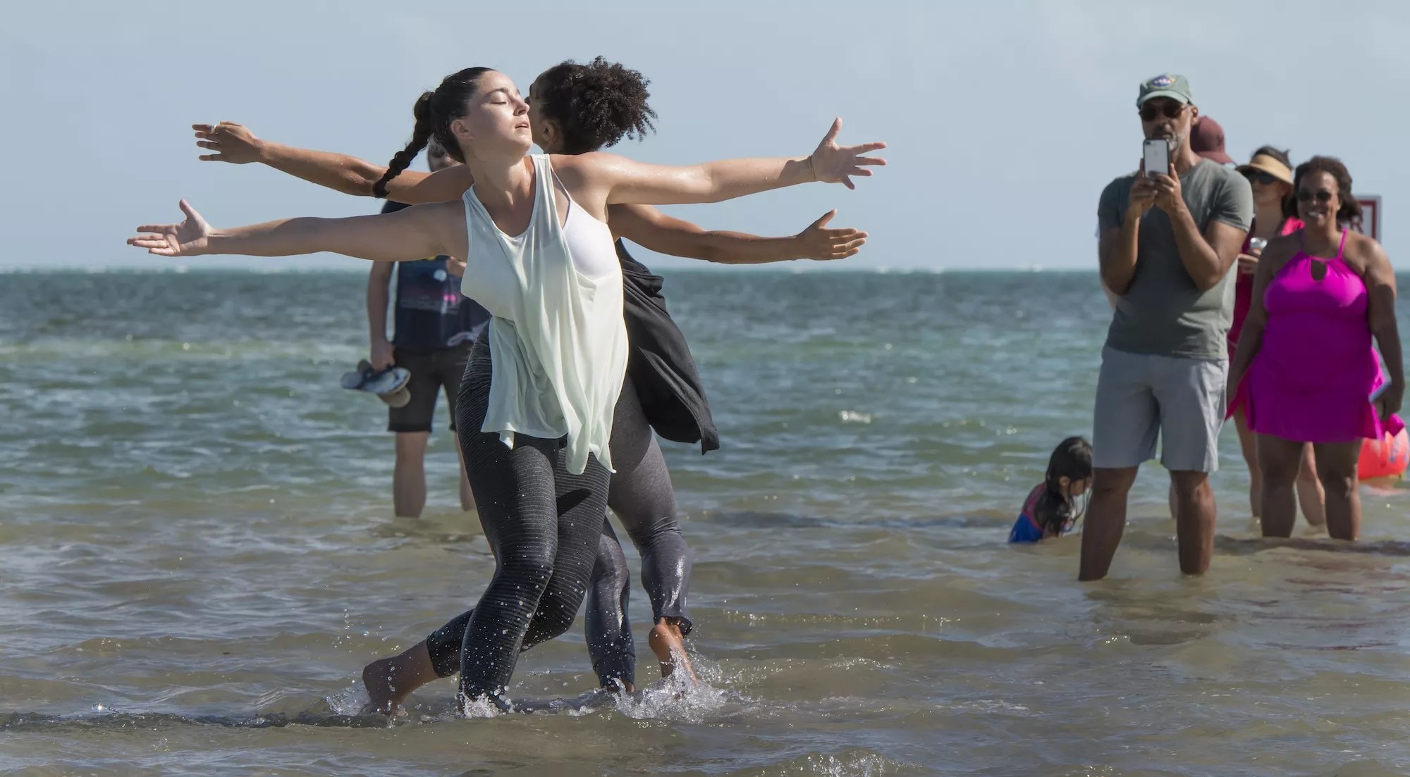 Dancers in the water while an audience watches