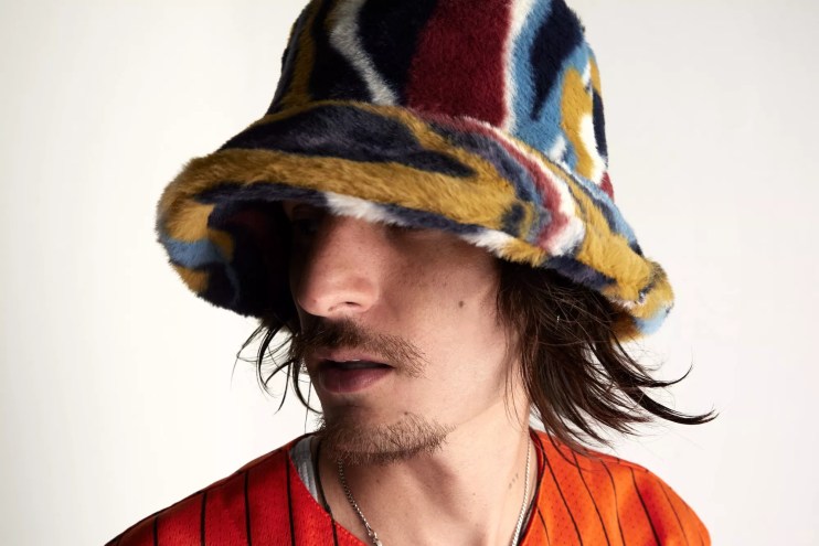 Danny Ocean wearing a bucket hat and orange shirt