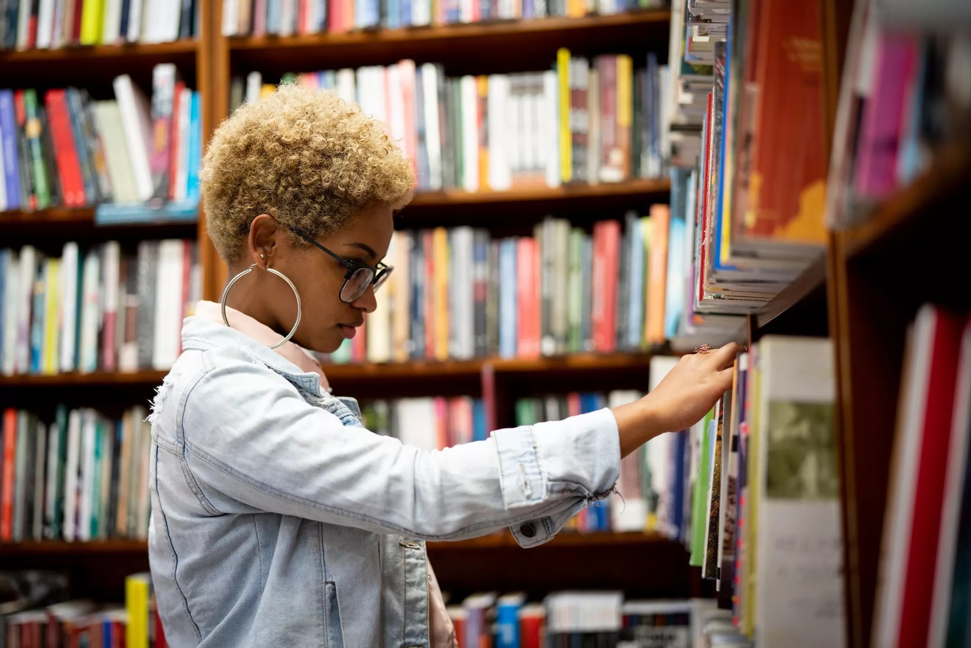 Woman browsing through bookshelves at a library
