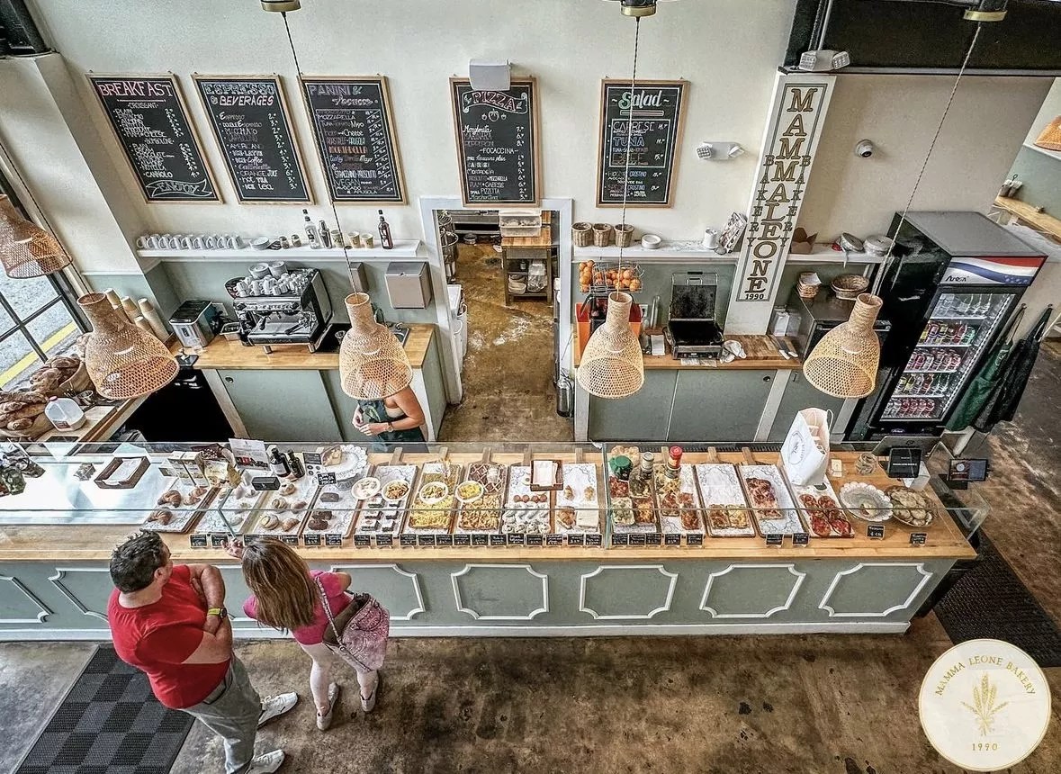 a bakery with pastel hues and pastries behind glass enclosures