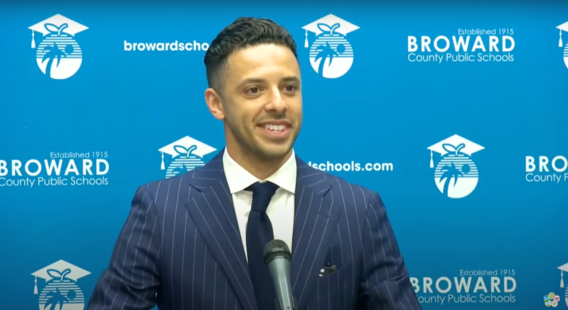 Broward School Board Daniel Foganholi candidate at a speaking podium.