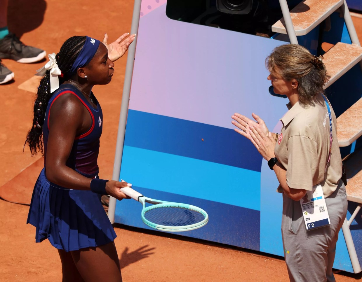 Coco Gauff is agitated and extending her hands after an unfavorable overrule by the chair umpire at the 2024 Olympics in Paris.