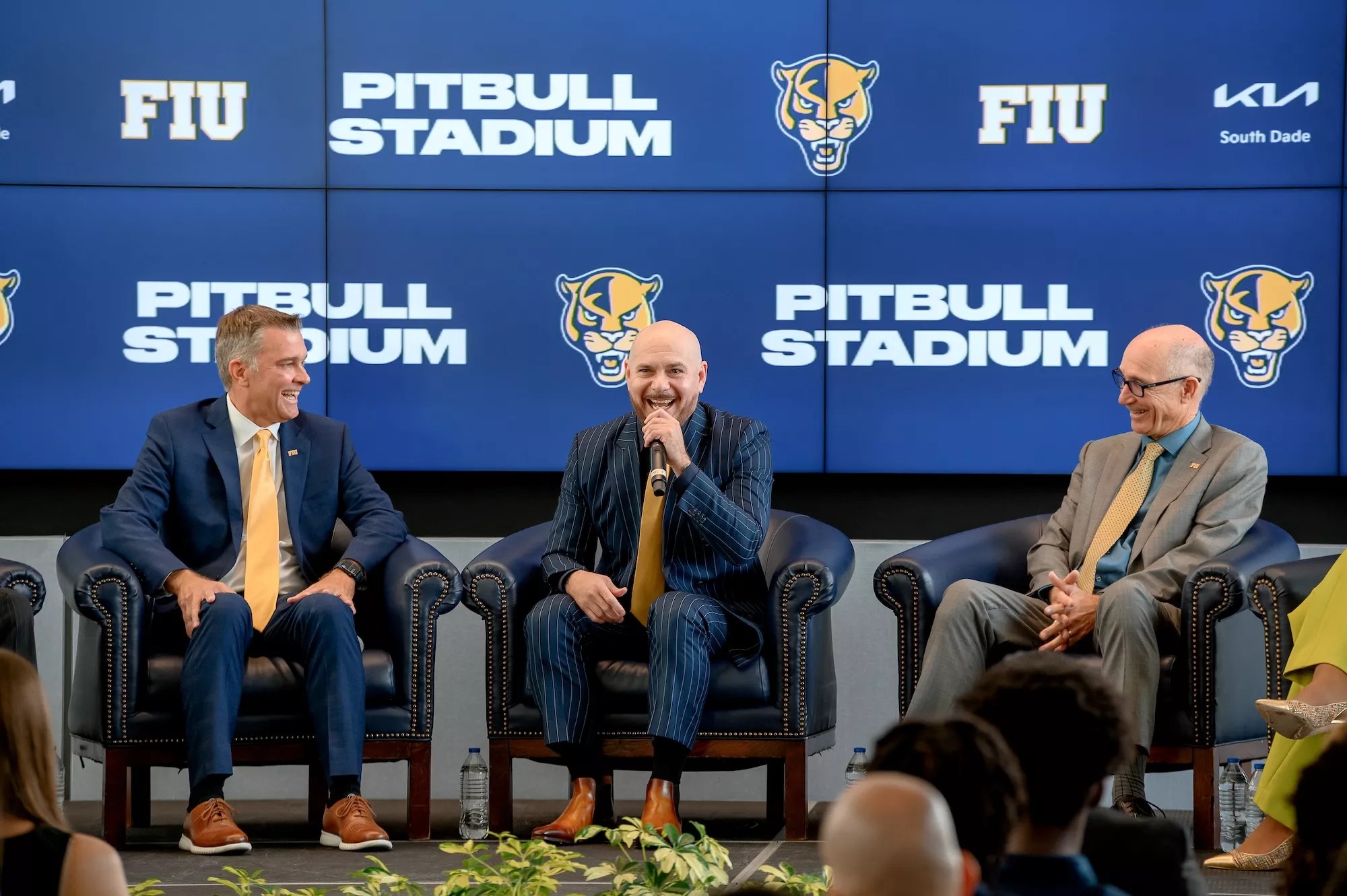 FIU athletics director Scott Carr, Pitbull, and FIU president Kenneth Jessell on stage