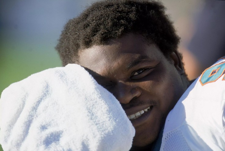 Lineman Tim Bowens smiles as he wipes his forehead with a towel during a game