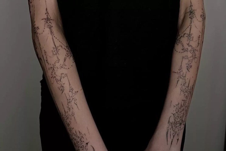 Arms tattooed with a cybersigilism design