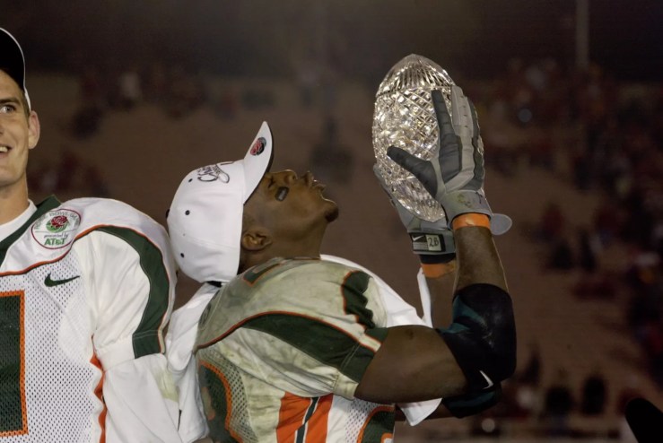 Photo of UM running back Clinton Portis holding aloft the NCAA football national championship trophy.