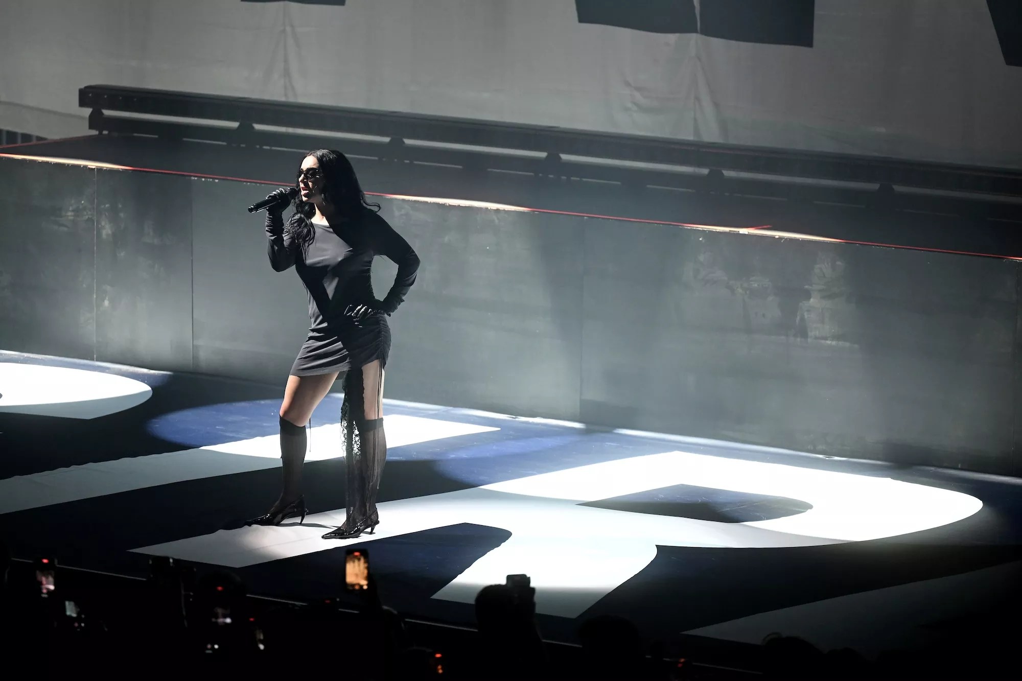 Charli XCX performing on stage in London