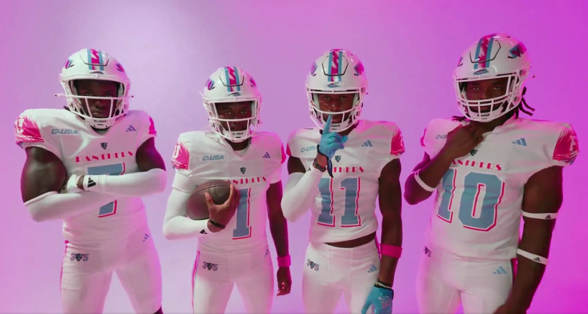 Four FIU football players wearing white<i> Miami Vice</i>-themed jerseys with pink and aqua accents, posing against a bright pink background