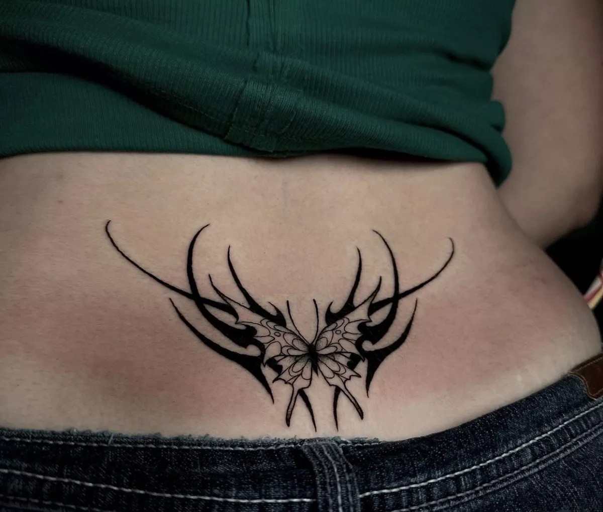 Woman with a tribal style lower back tattoo