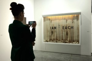 Woman snapping a photo of an artwork at Art Basel Miami Beach 2024