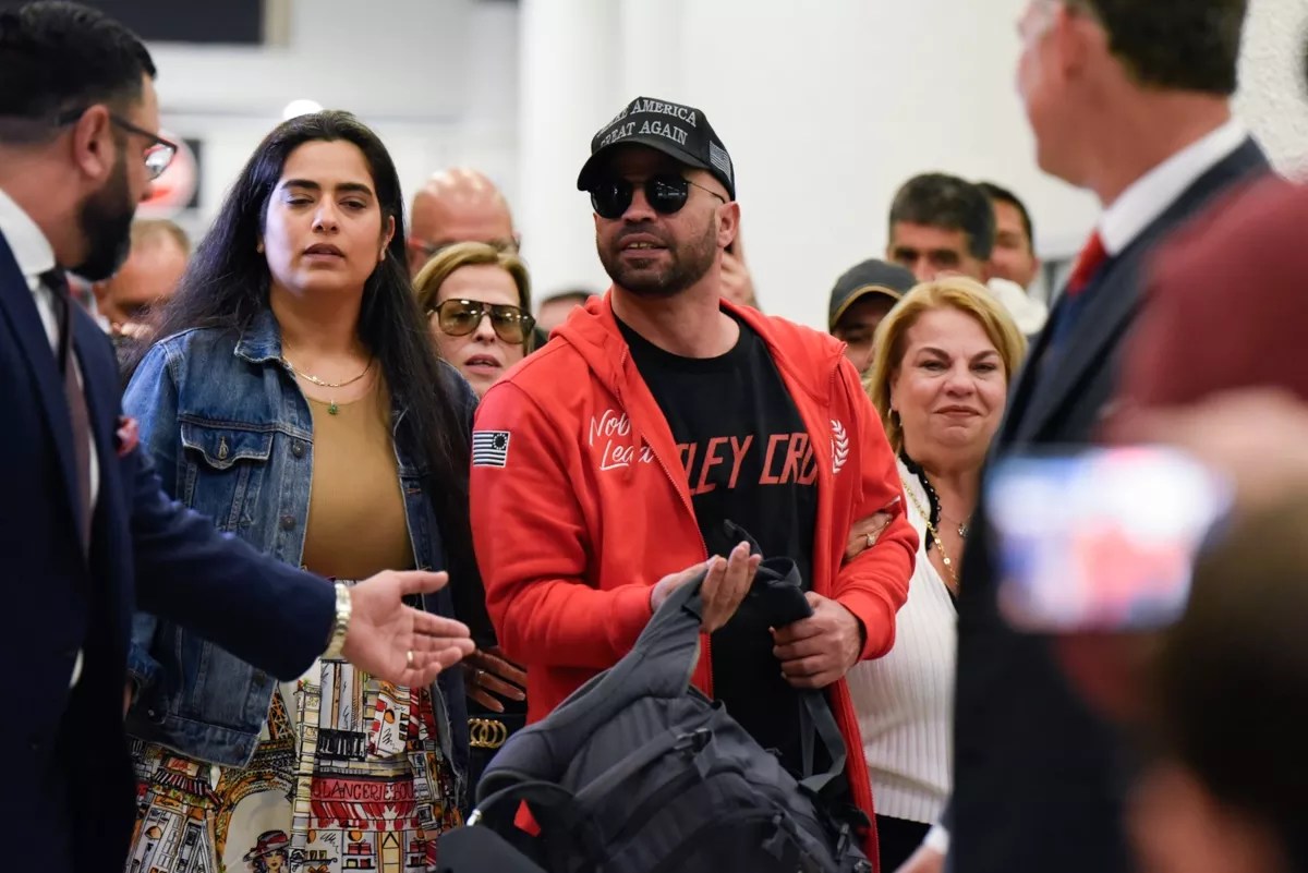 Enrique Tarrio surrounded by people at the Miami Airport
