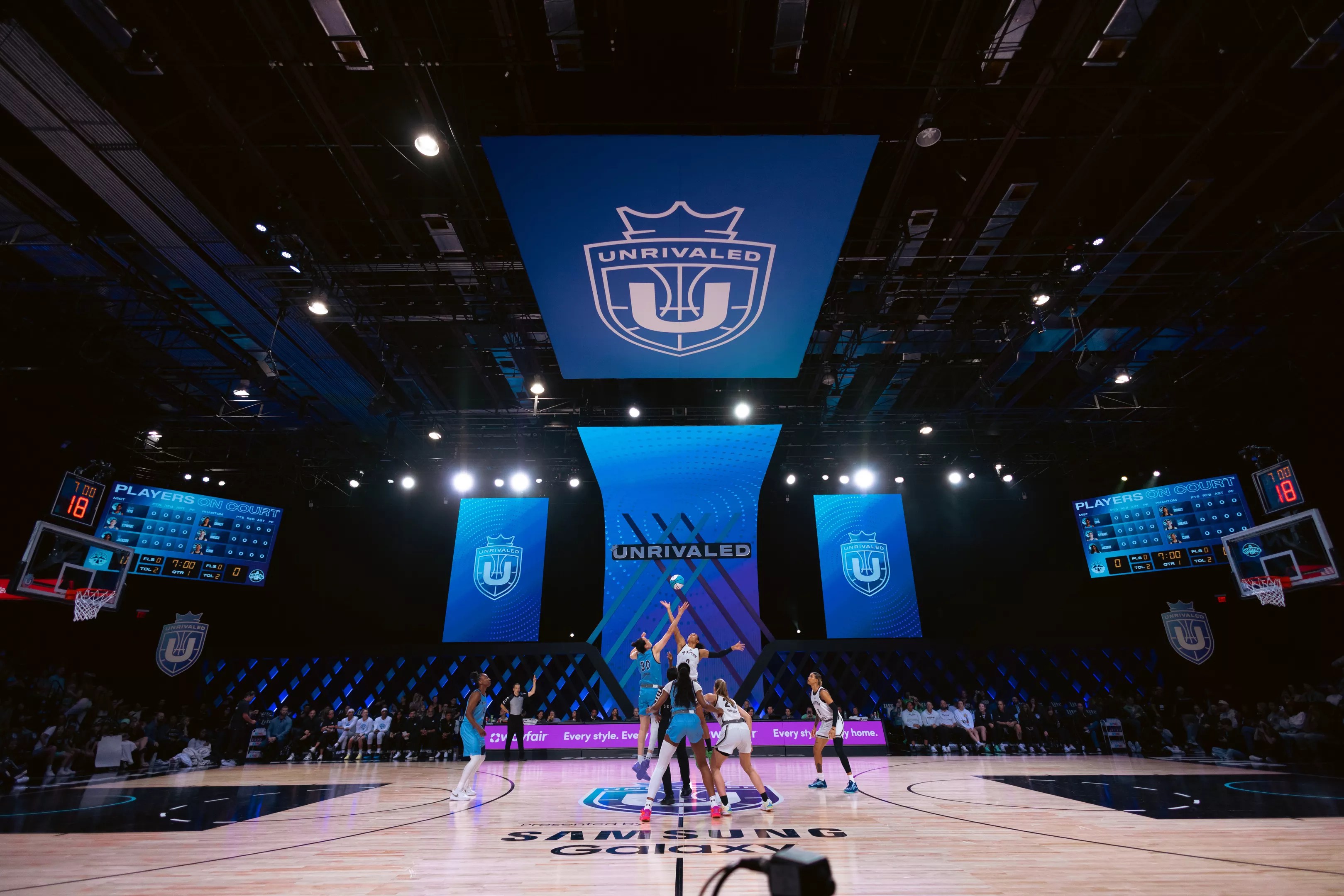 basketball players reach for a basketball on a court