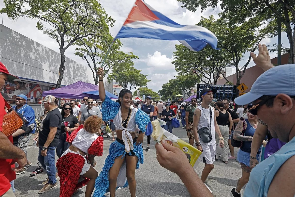 People dance in the streets and waving flags during Calle Ocho