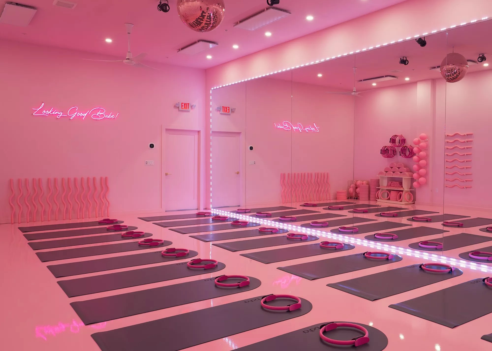 a studio lit in pink lighting with mats on the floor