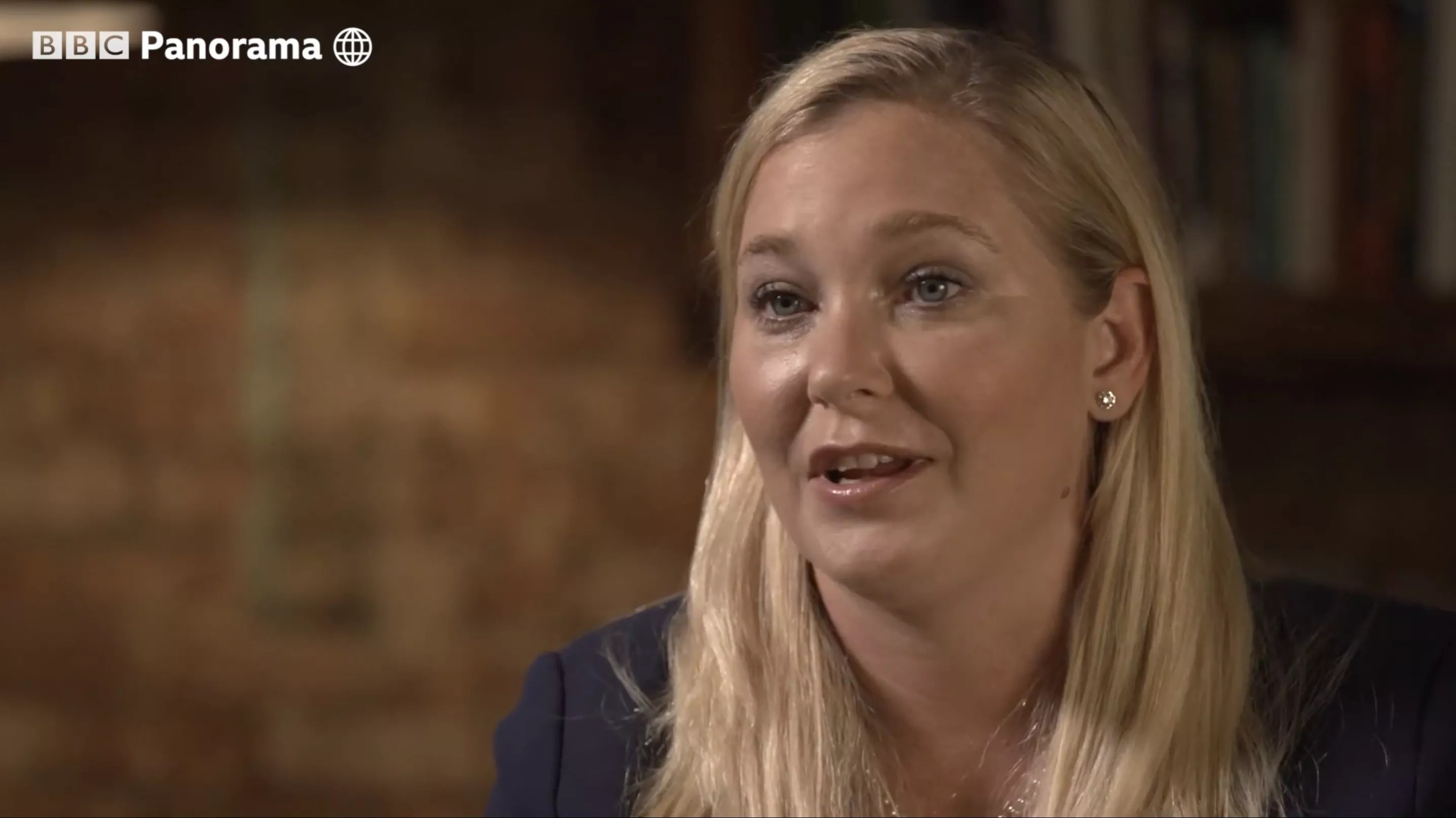 a blond woman speaking during a filmed interview