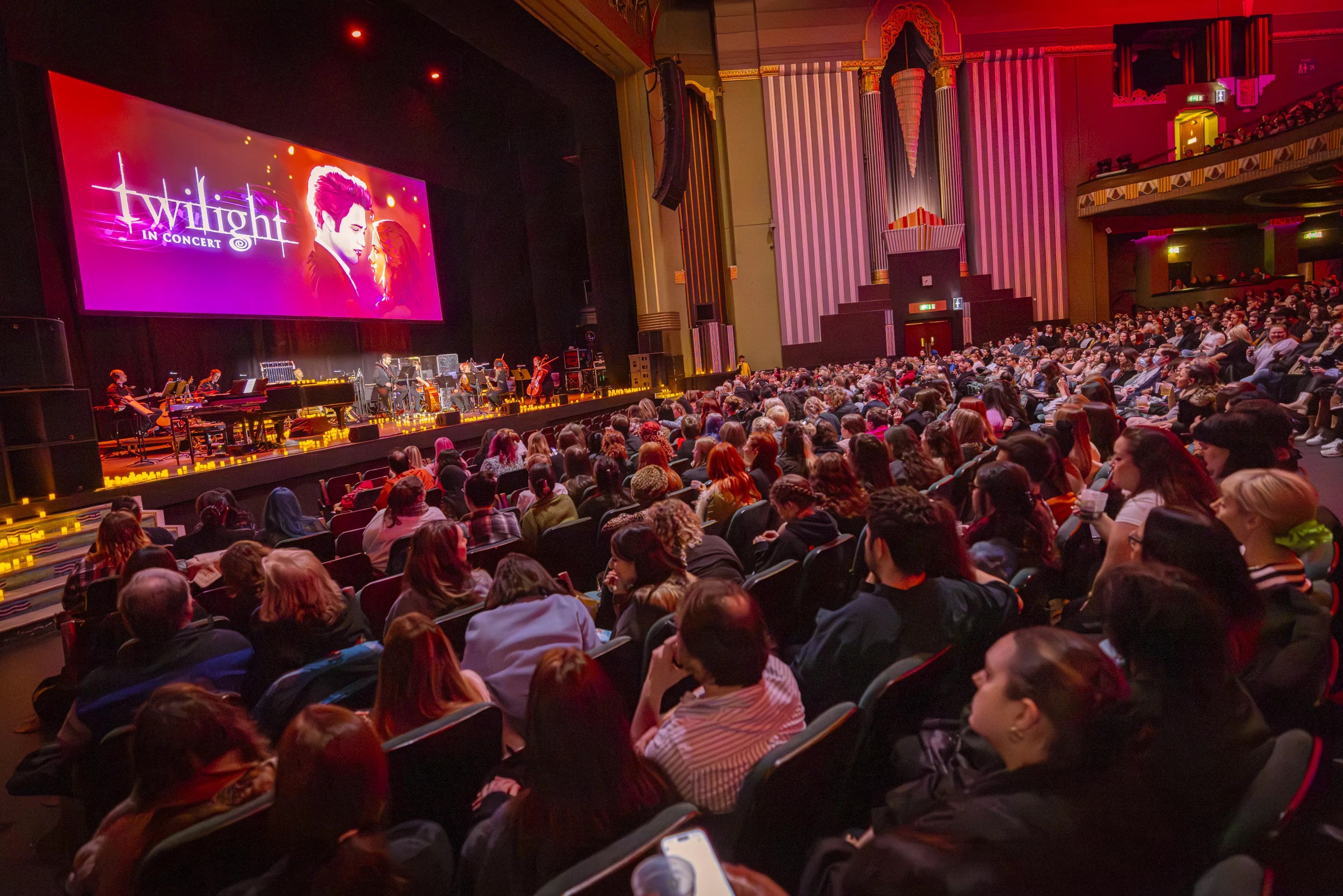 a crowd in a theater. the screen on the stage reads "Twilight in Concert"