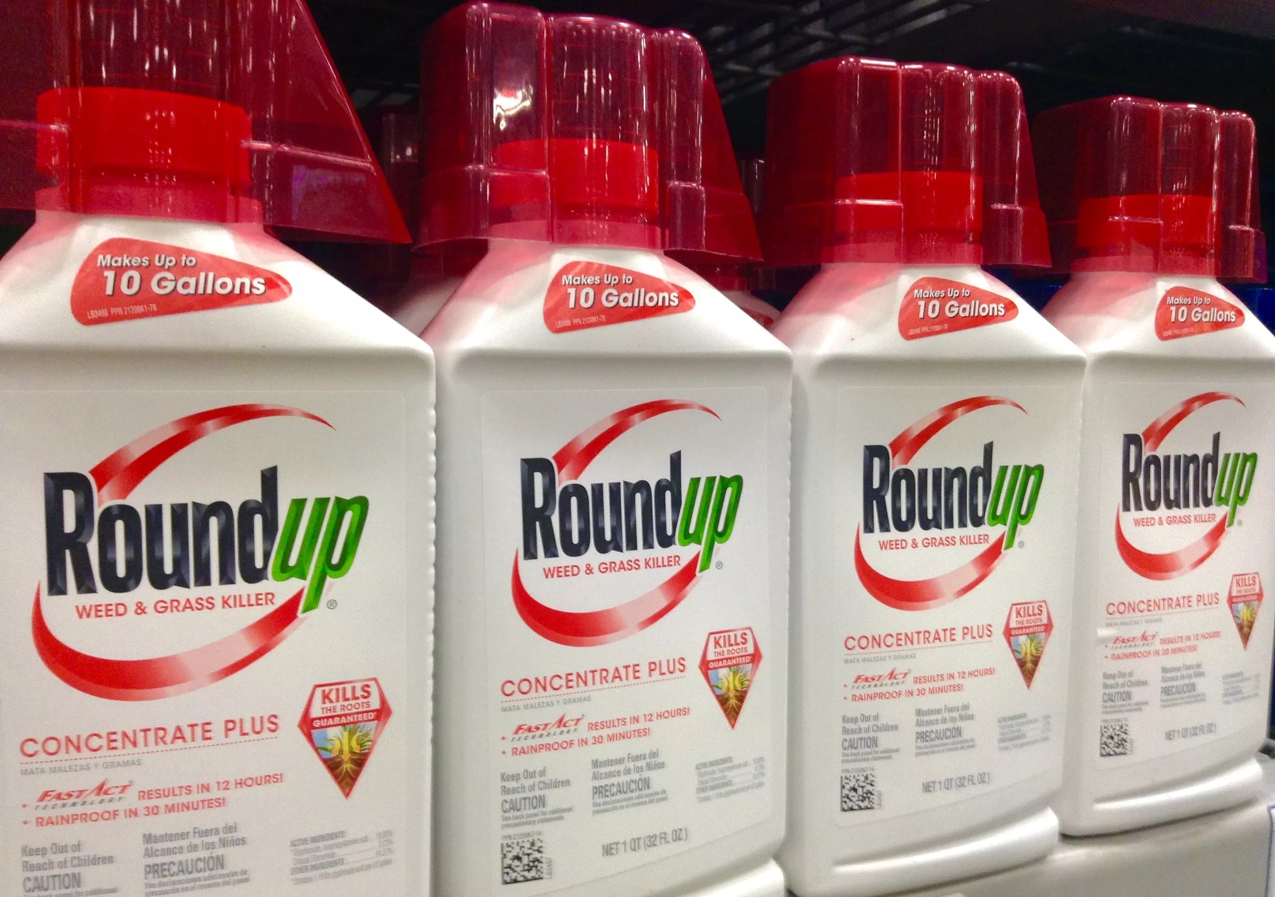 Bottles of herbicide "Roundup" sit on a shelf.