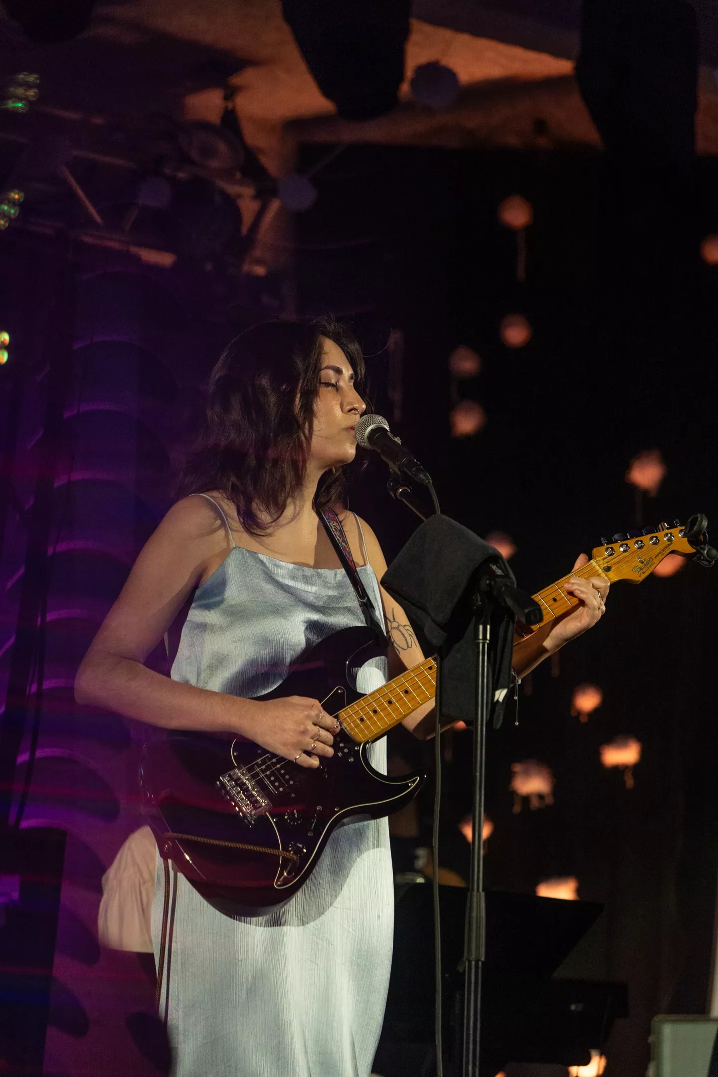 Singer Vania Junco plays guitar and sings on stage