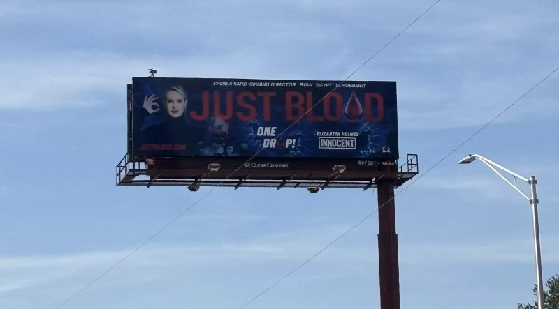 A billboard shows a blonde woman with the words "just blood" in bold print beside her.