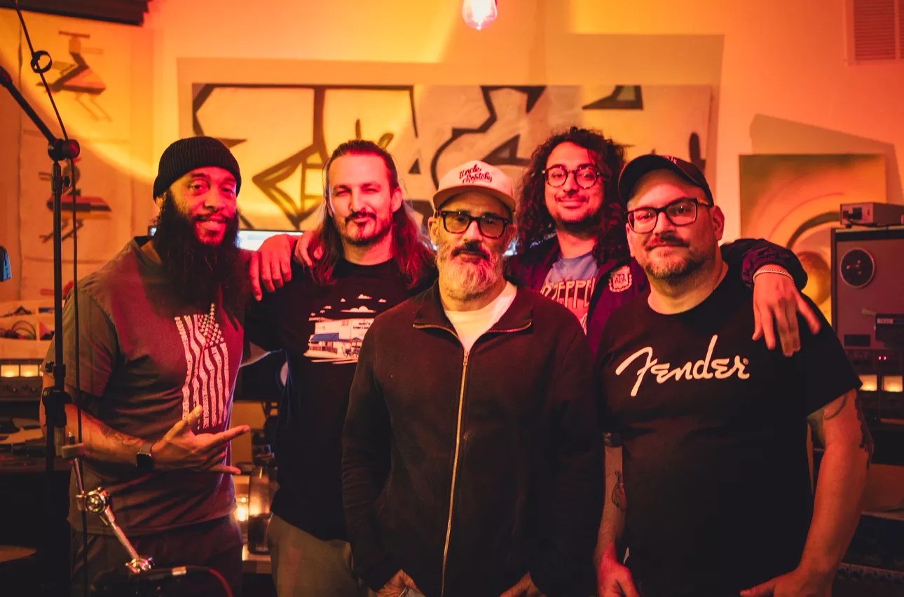 5 musicians posing for the camera.