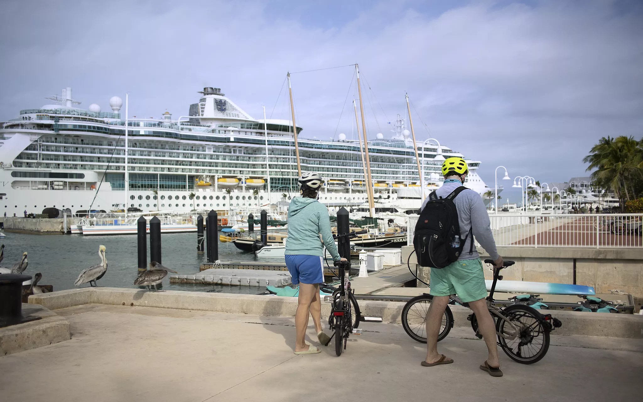 two cyclists stand with their bikes in front of a cruise shop