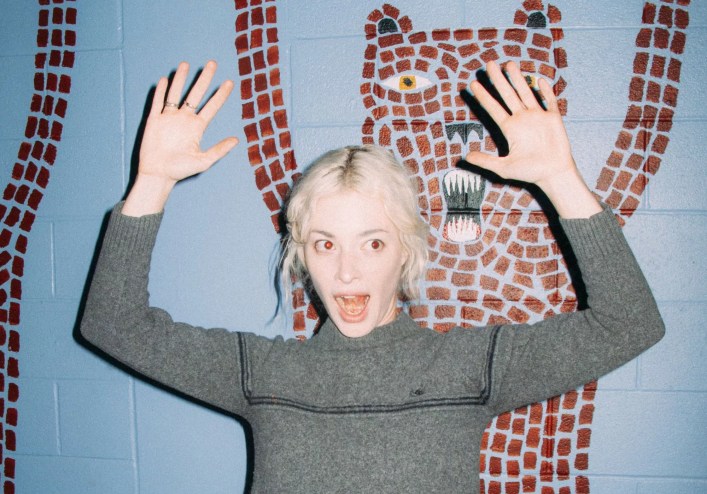 Picture of a blonde woman with her hands up