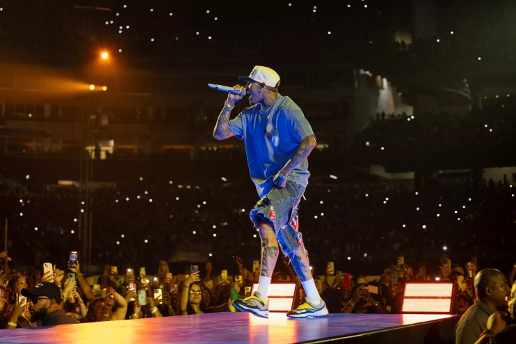 A man singing with a mic on stage in front of a crowd.