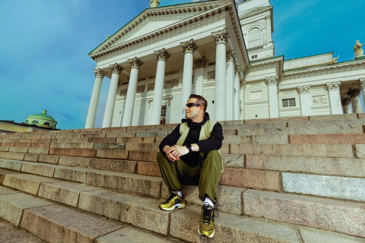 A man sitting on a stair in front of a church.