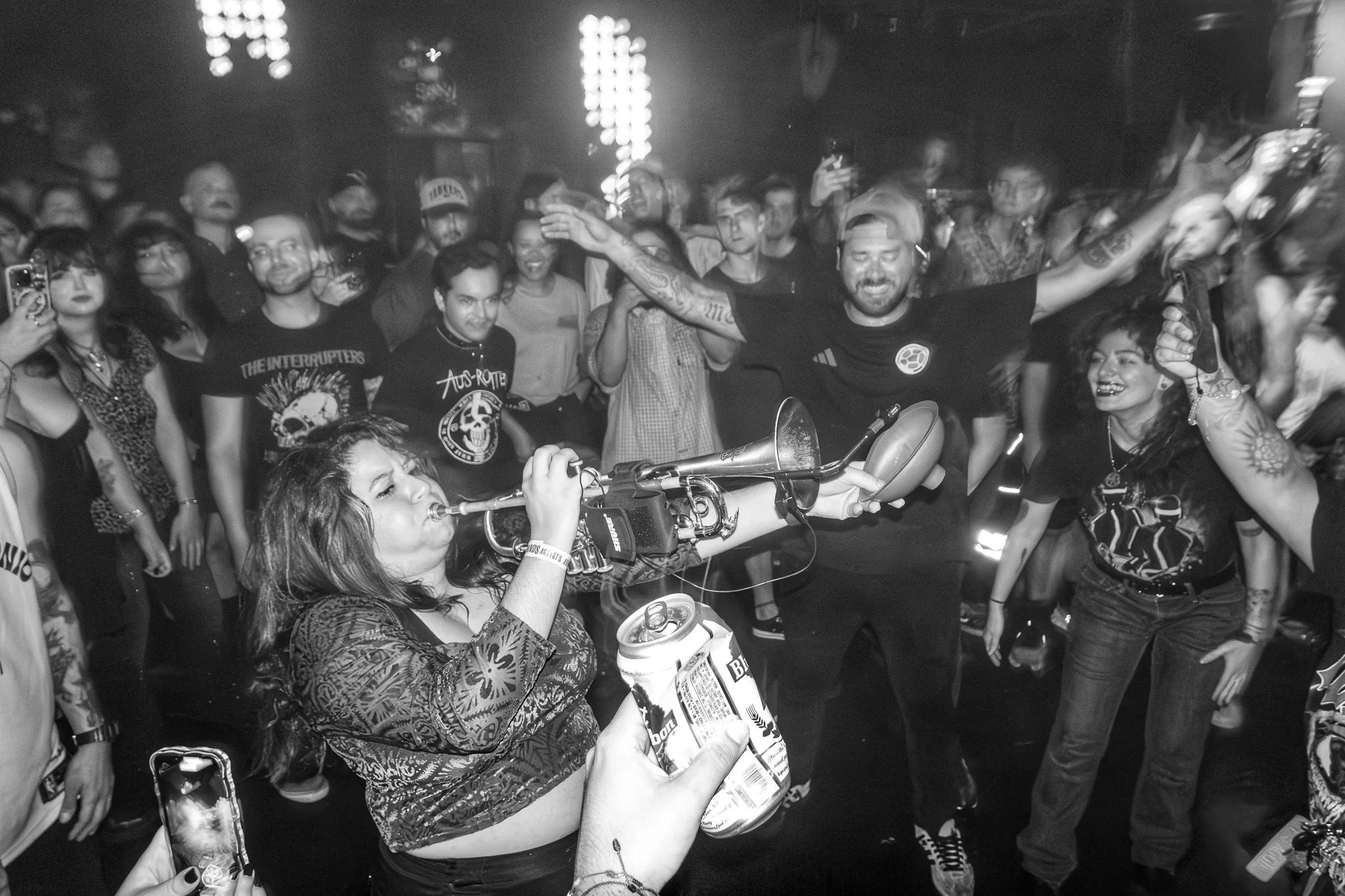 Black and white picture of people dancing around a trumpet player.
