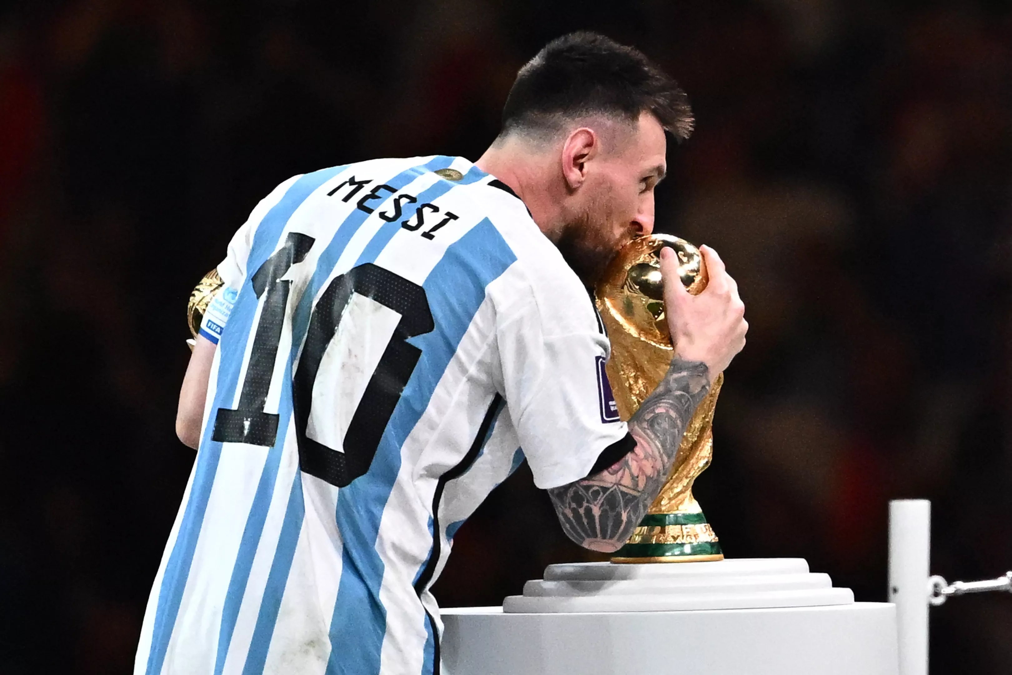 Soccer legend Lionel Messi kisses the World Cup trophy.