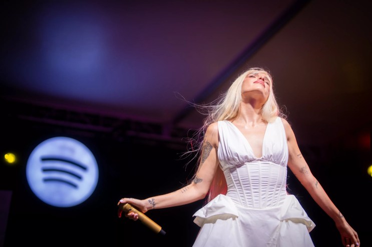 Picture of singer Elena Rose on stage wearing a white dress.